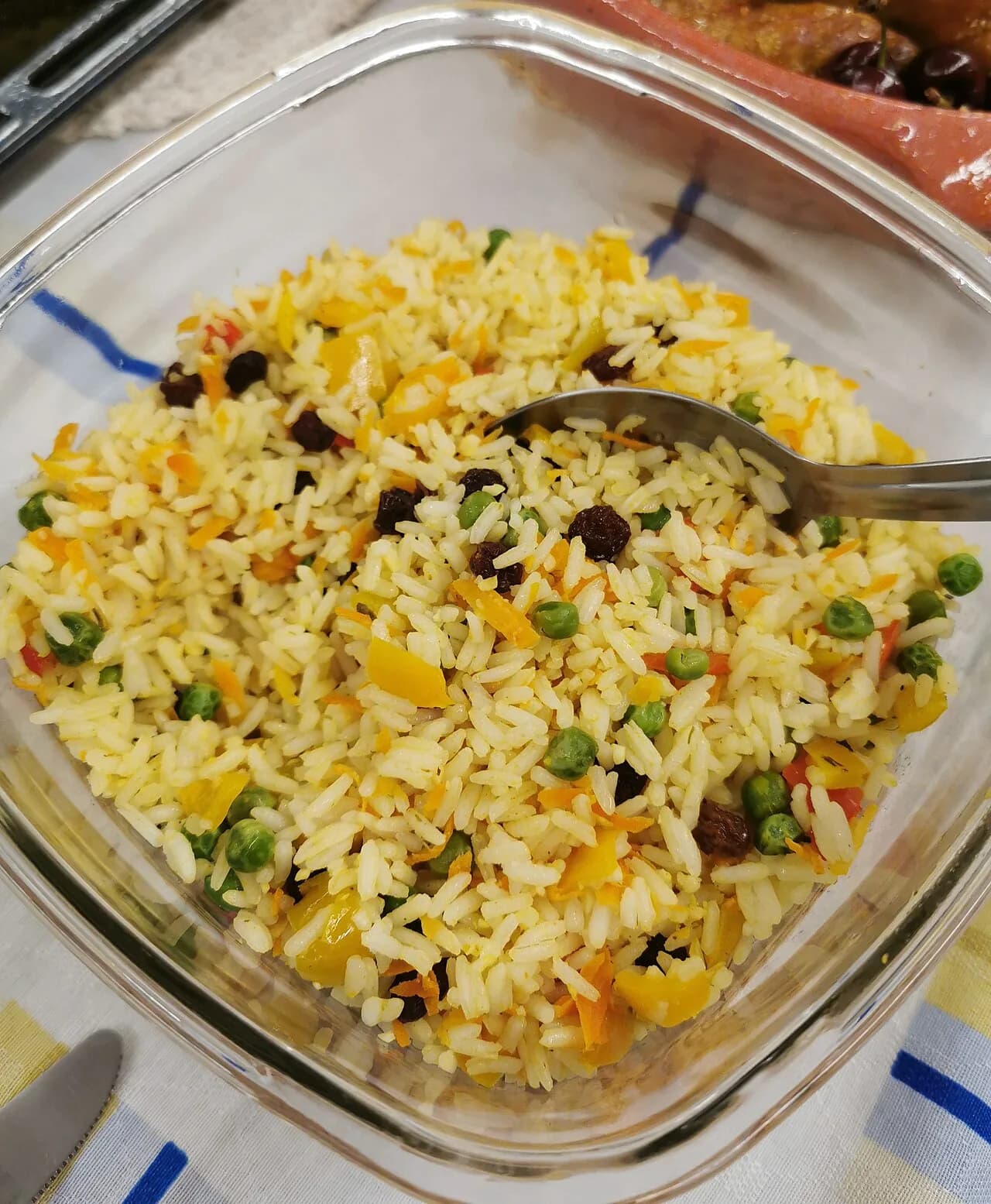 Foto da receita: Arroz à Grega - Arroz branco colorido com cenoura, ervilha, milho, pimentão e uva passa. O acompanhamento das ceias de Natal e dos almoços de festa.