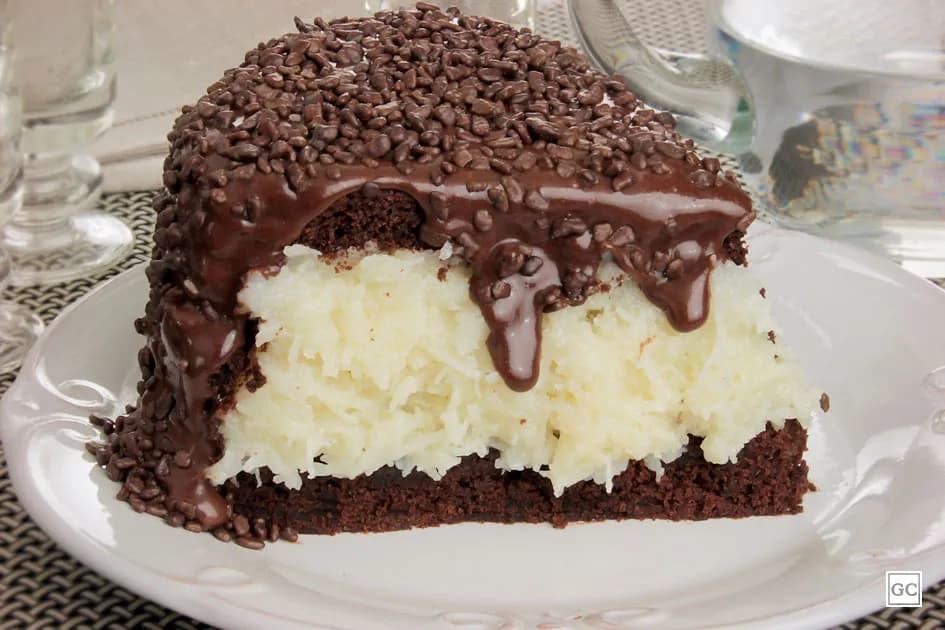 Foto da receita: Bolo Prestígio - Bolo de chocolate molhadinho com recheio de coco branco cremoso, coberto com ganache. Inspirado no chocolate Prestígio.
