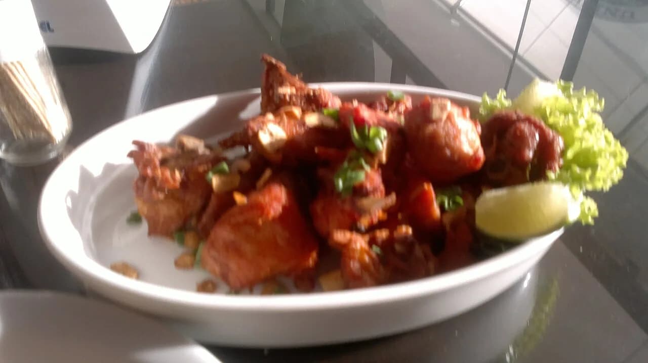 Foto da receita: Frango a Passarinho - Pedaços pequenos de frango marinados em alho e limão, fritos até ficarem crocantes e finalizados com alho frito e salsinha. O petisco que não sai da mesa do boteco.