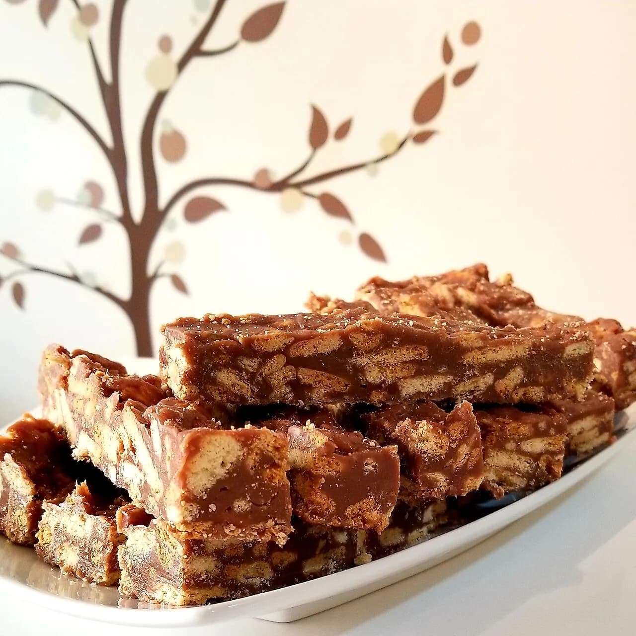 Foto da receita: Palha Italiana - Brigadeiro de panela misturado com biscoito maisena quebrado, espalhado, gelado e cortado em quadradinhos passados no açúcar. Pronto em 30 minutos.