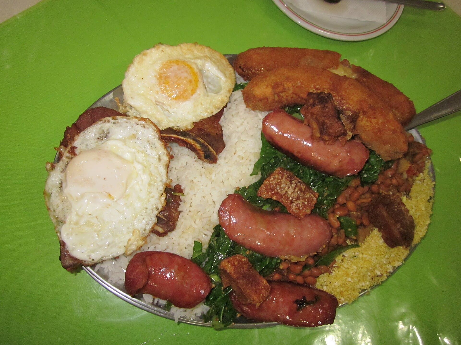 Foto da receita: Virado à Paulista - Tutu de feijão, arroz branco, couve refogada, bisteca, ovo frito e banana à milanesa — o prato bandeira de São Paulo.