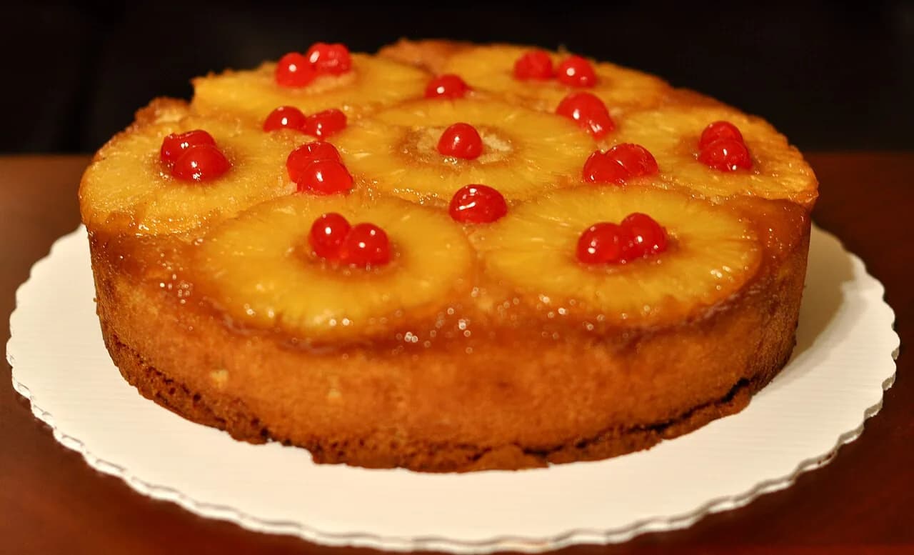 Foto da receita: Bolo de Abacaxi Caramelizado (de Virar) - Rodelas de abacaxi caramelizadas no fundo da forma e massa fofinha por cima. Ao desenformar, a fruta brilhante fica à mostra. Bolo de festa sem cobertura.