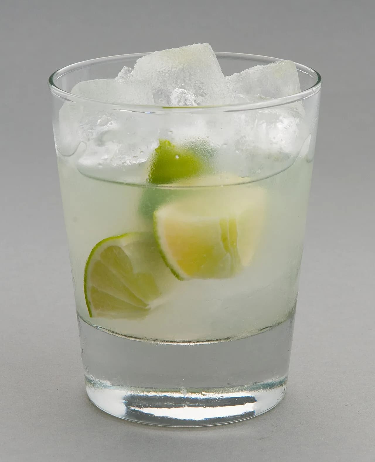 Foto da receita: Caipirinha Tradicional - Limão macerado com açúcar, cachaça e gelo, feita direto no copo. O drink nacional brasileiro, com as proporções e a técnica do bartender para não ficar amarga nem aguada.