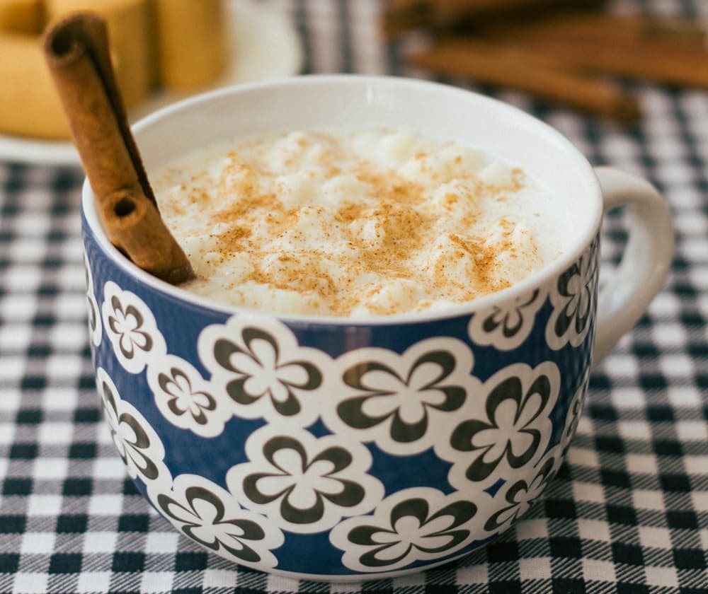 Foto da receita: Canjica Branca de Festa Junina - Milho branco cozido com leite, leite condensado, leite de coco e cravo. Sopa doce, cremosa, sabor de fogueira.
