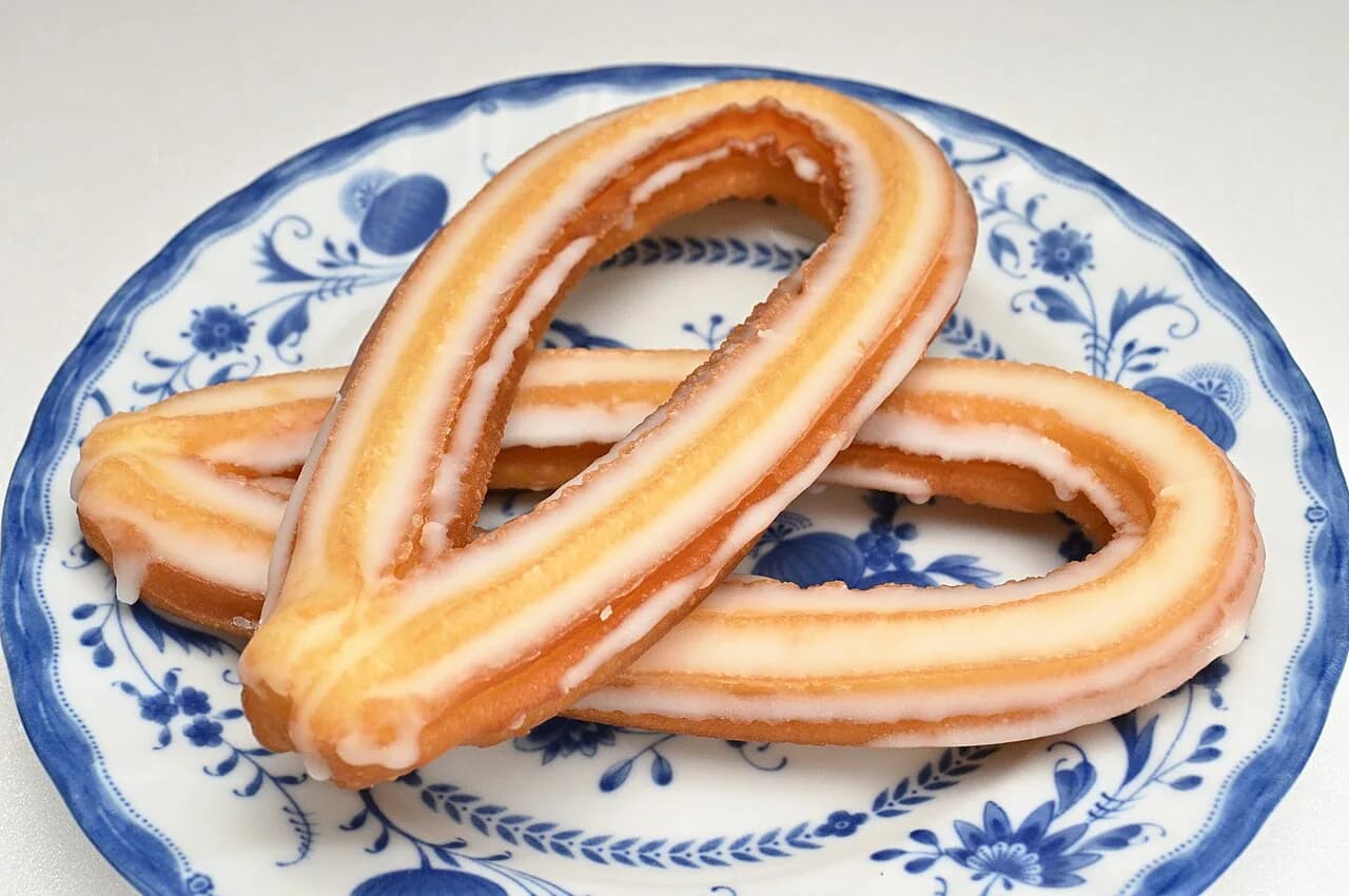 Foto da receita: Churros com Doce de Leite - Massa de churros feita na panela, modelada com bico pitanga, frita até dourar, passada no açúcar com canela e recheada com doce de leite. Como os da praça.