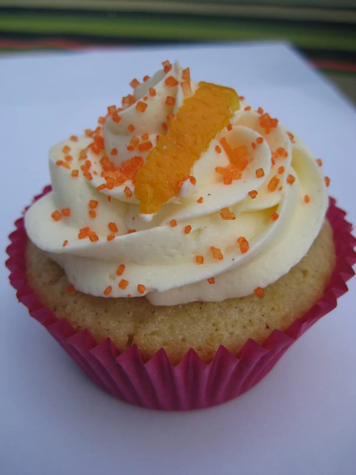 Foto da receita: Cupcake de Baunilha com Buttercream - Cupcakes fofinhos de baunilha com cobertura de buttercream de manteiga, firme o bastante para decorar com bico de confeitar. Rende 12 unidades.