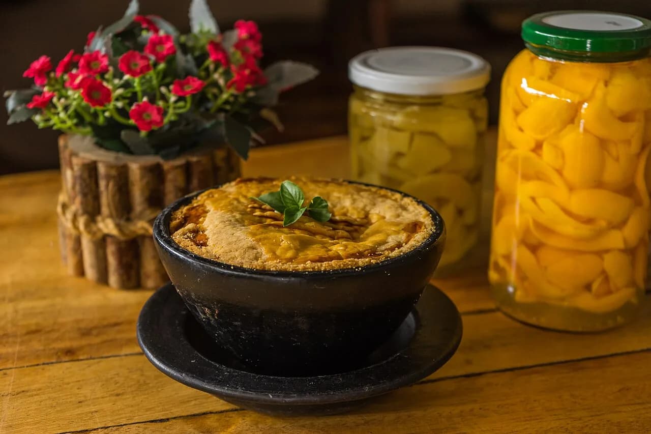 Foto da receita: Empadão de Frango - Massa podre amanteigada que esfarela na boca, recheada com frango desfiado cremoso, azeitona e palmito. O empadão de família para servir em fatias no almoço de domingo.