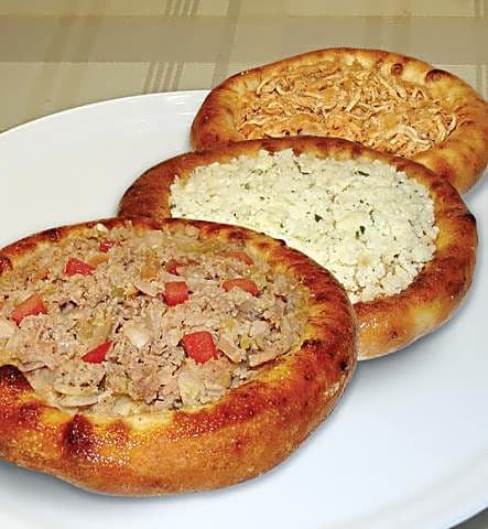 Foto da receita: Esfiha Aberta de Carne Síria - Discos de massa macia com cobertura de carne moída, cebola, tomate e limão siciliano. Tradição síria que virou esquina de boteco brasileiro.