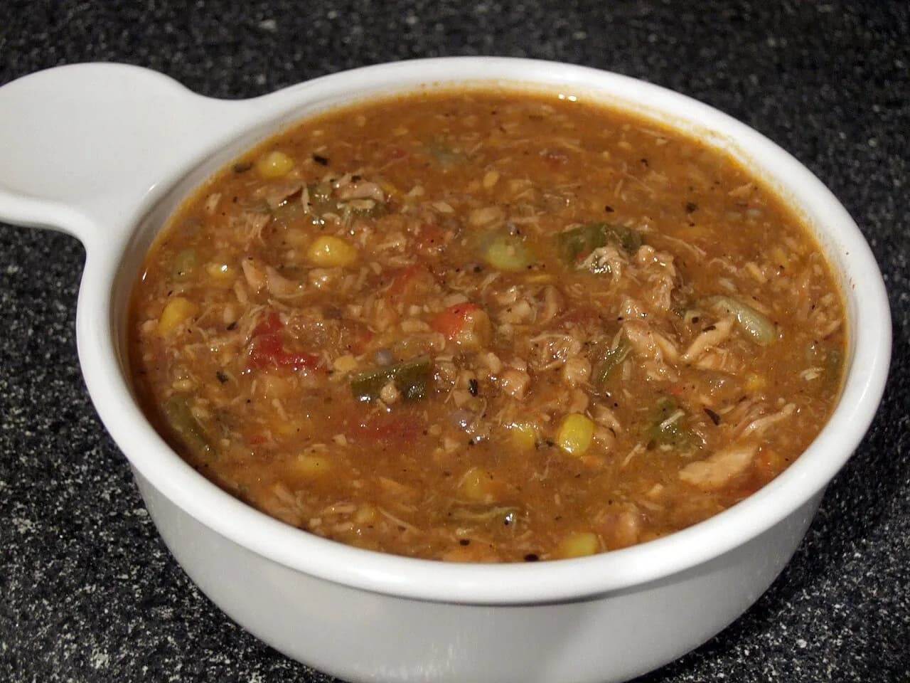 Foto da receita: Frango com Quiabo à Mineira - Frango caipira em pedaços refogado com quiabo, tomate e cheiro-verde, sem a baba. Um dos pratos mais representativos da cozinha de Minas Gerais.