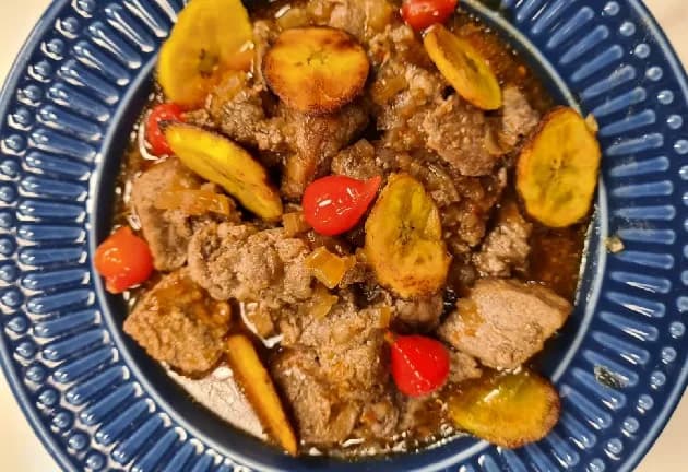 Foto da receita: Picadinho de Carne com Banana à Mineira - Carne em cubos refogada lentamente com cebola, alho e cerveja preta, finalizada com bananas caramelizadas por cima. Doce, salgado e marcante.