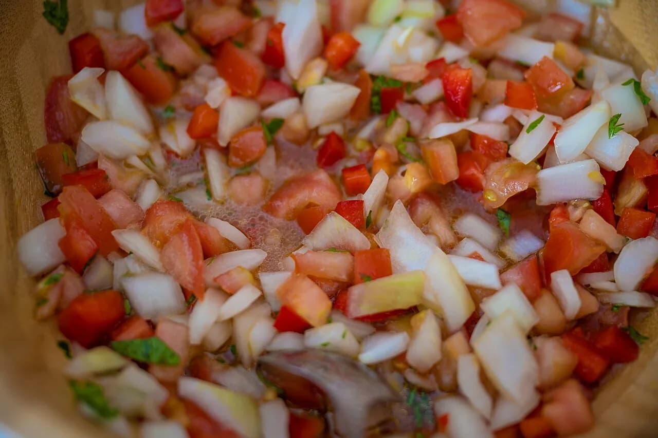 Foto da receita: Vinagrete de Churrasco - Tomate, cebola e pimentão picados em cubos pequenos, temperados com vinagre, azeite, sal e cheiro-verde. O molho fresco que acompanha churrasco, feijoada e peixe frito.
